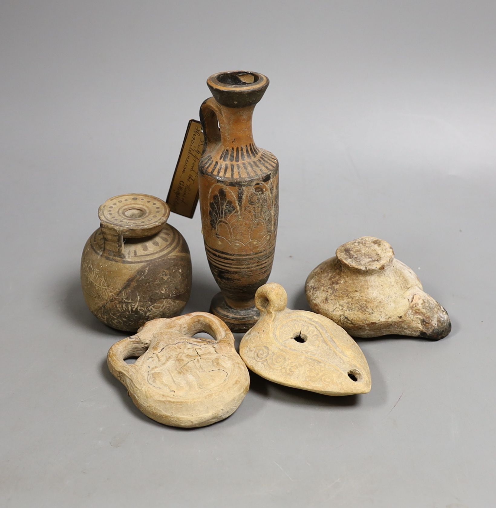 Two Ancient Greek painted pottery vessels, Apulia 3rd-4th century BC, two Roman/Byzantine oil lamps and a pilgrim flask, Tallest 15 cms high (5)